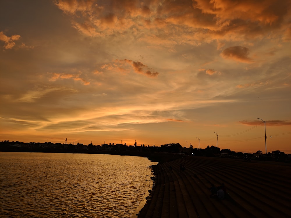 body of water under cloudy sky during sunset