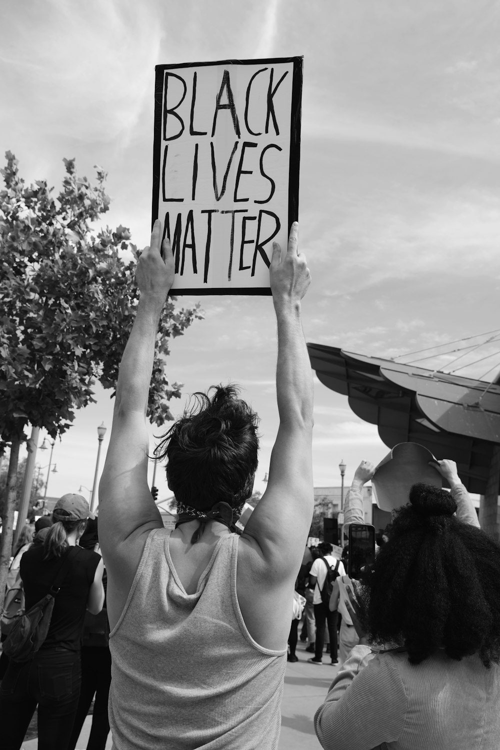 grayscale photo of woman raising her hands