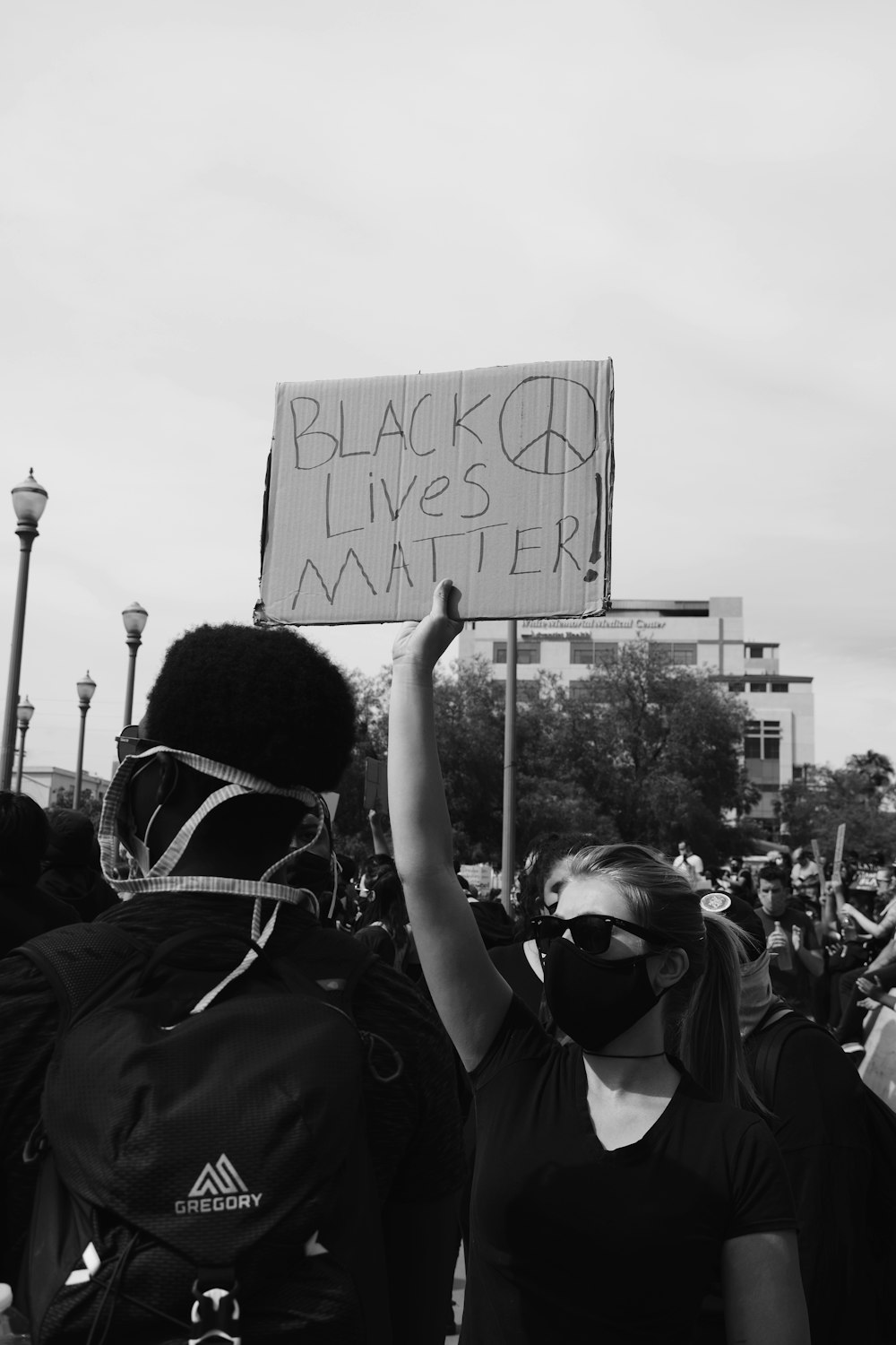 grayscale photo of people holding wall art