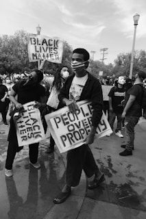 grayscale photo of people holding white and black t-shirt