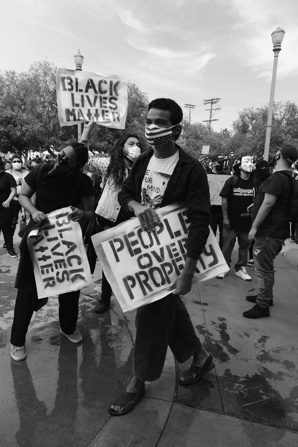 grayscale photo of people holding white and black t-shirt