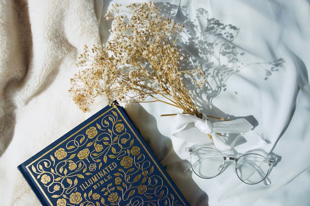 blue and gold book on white textile