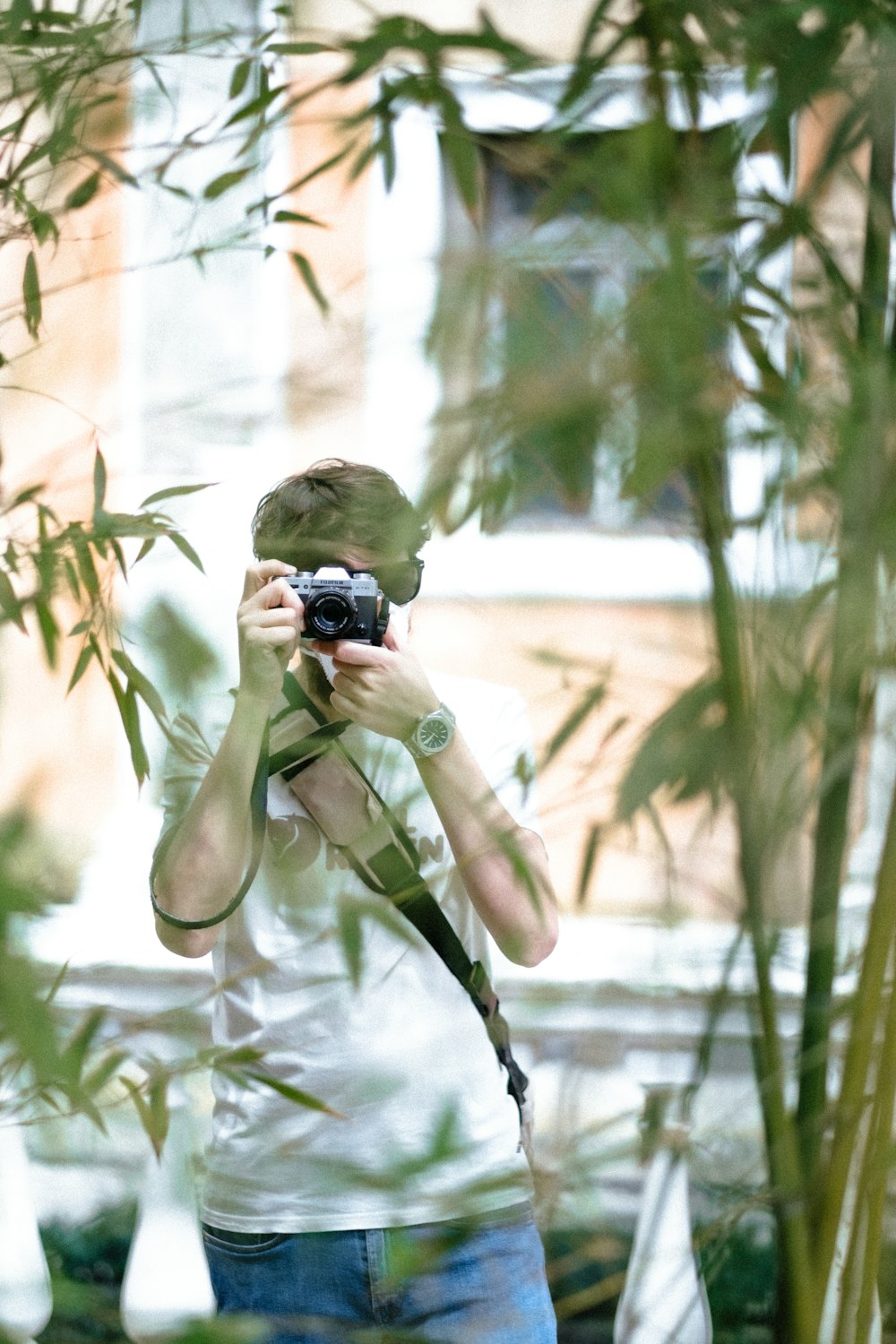 Mujer con abrigo verde sosteniendo una cámara DSLR negra