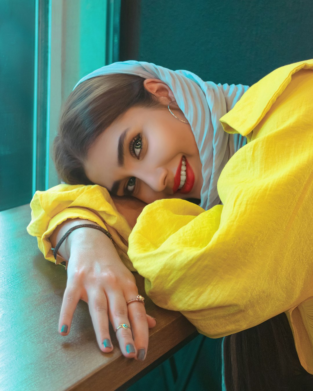 girl in yellow hoodie lying on bed