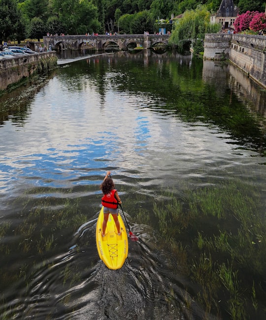 woman in yellow and red life vest on yellow kayak on river during daytime in Brantôme France