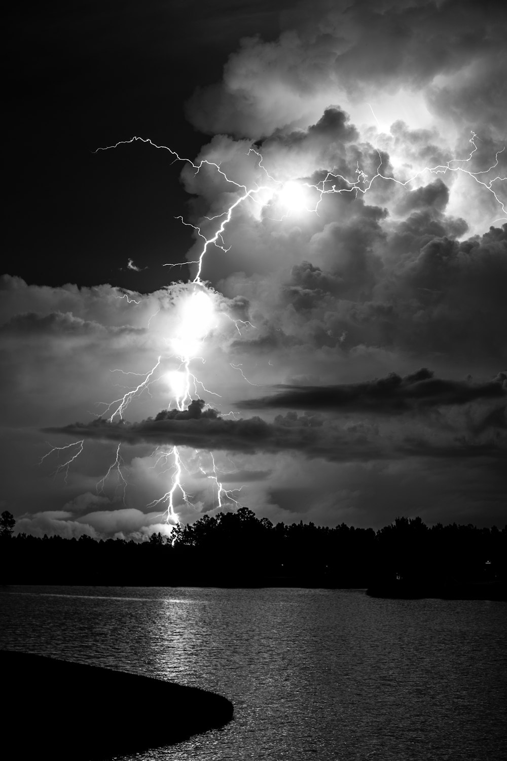 grayscale photo of lightning over body of water