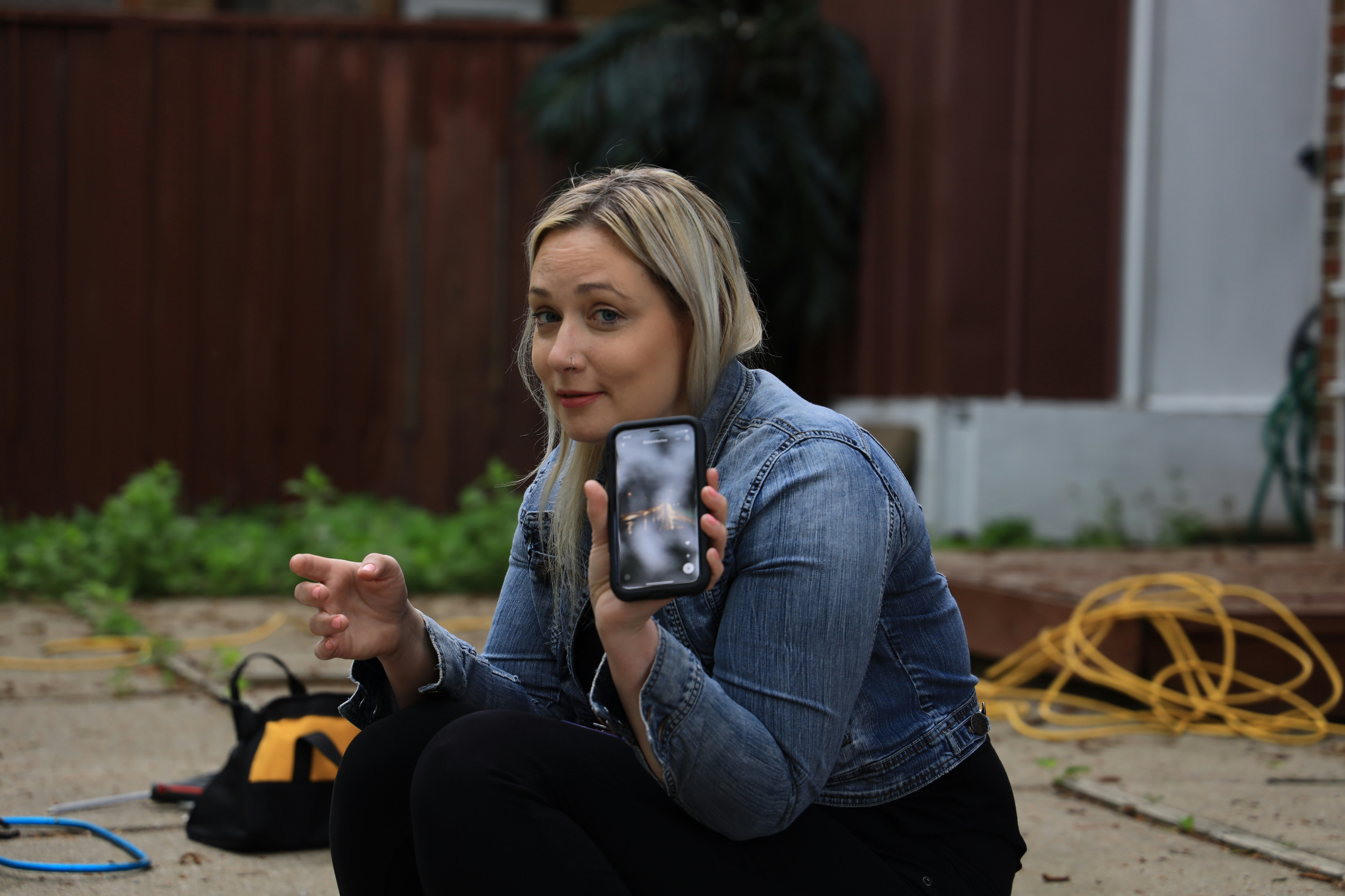 homeowner documenting roof damage with smartphone after Southern Oregon storm