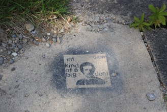 Close-up of a stencil work being applied on pavement.