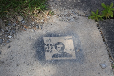 Close-up of a stencil work being applied on pavement.