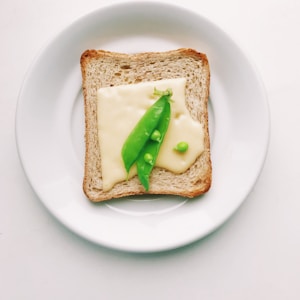 bread with green vegetable on white ceramic plate