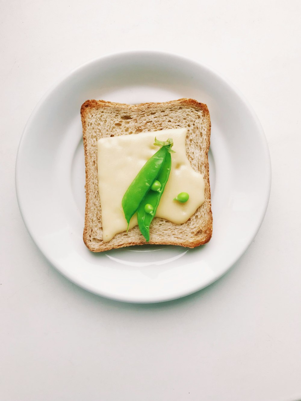 bread with green vegetable on white ceramic plate