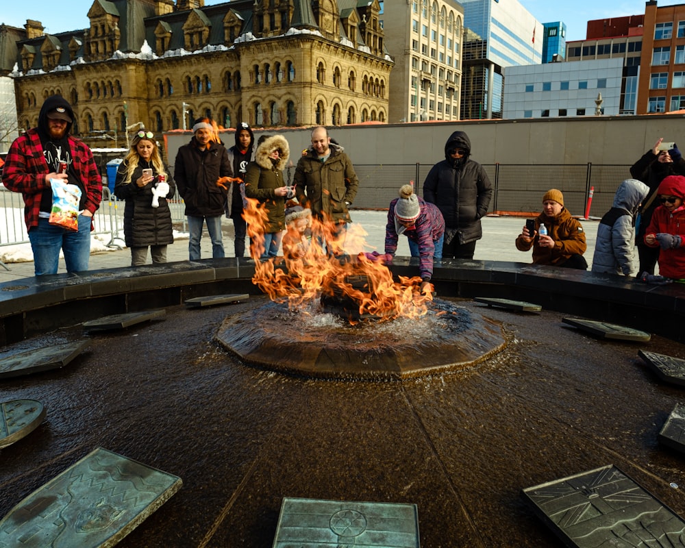 people standing near fire pit during daytime