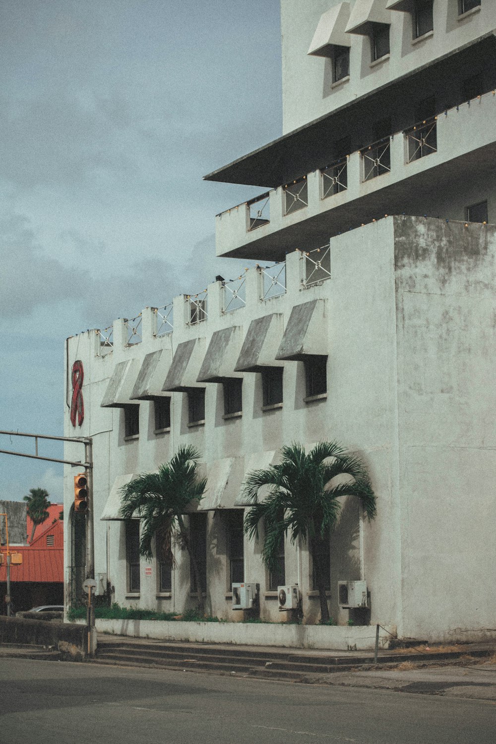 Edificio de hormigón blanco cerca de palmeras durante el día