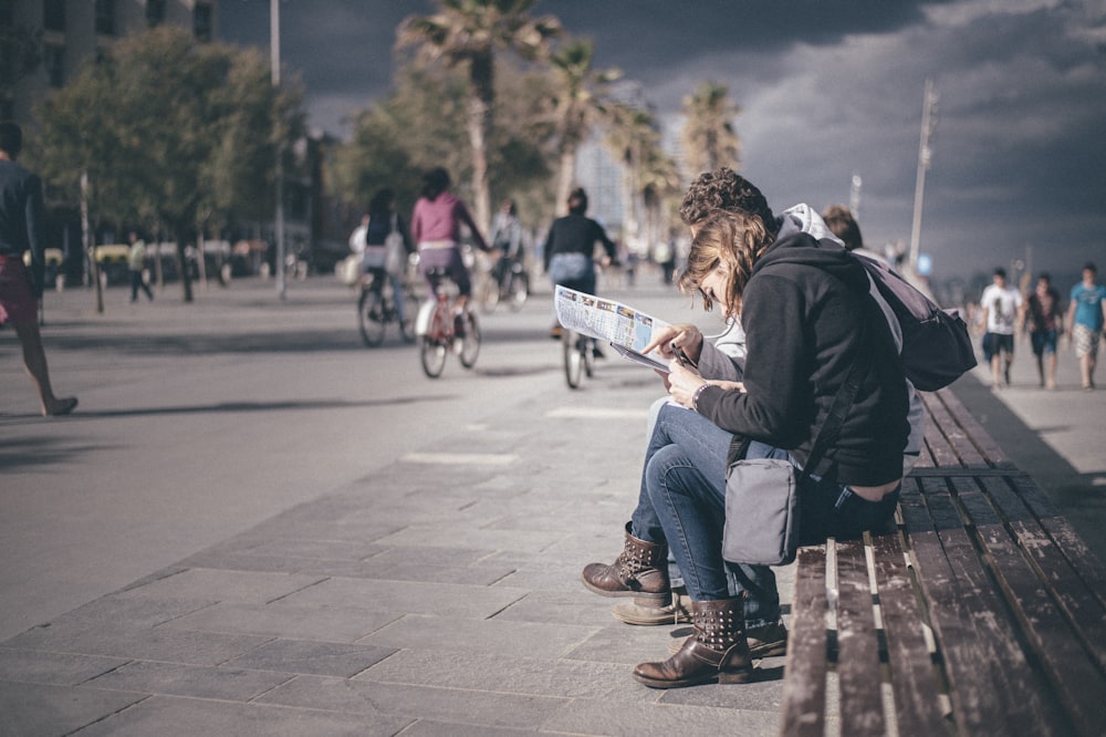 man and woman sitting on bench during daytime