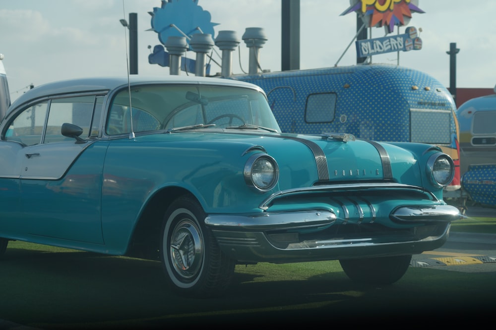 blue classic car on green grass field during daytime