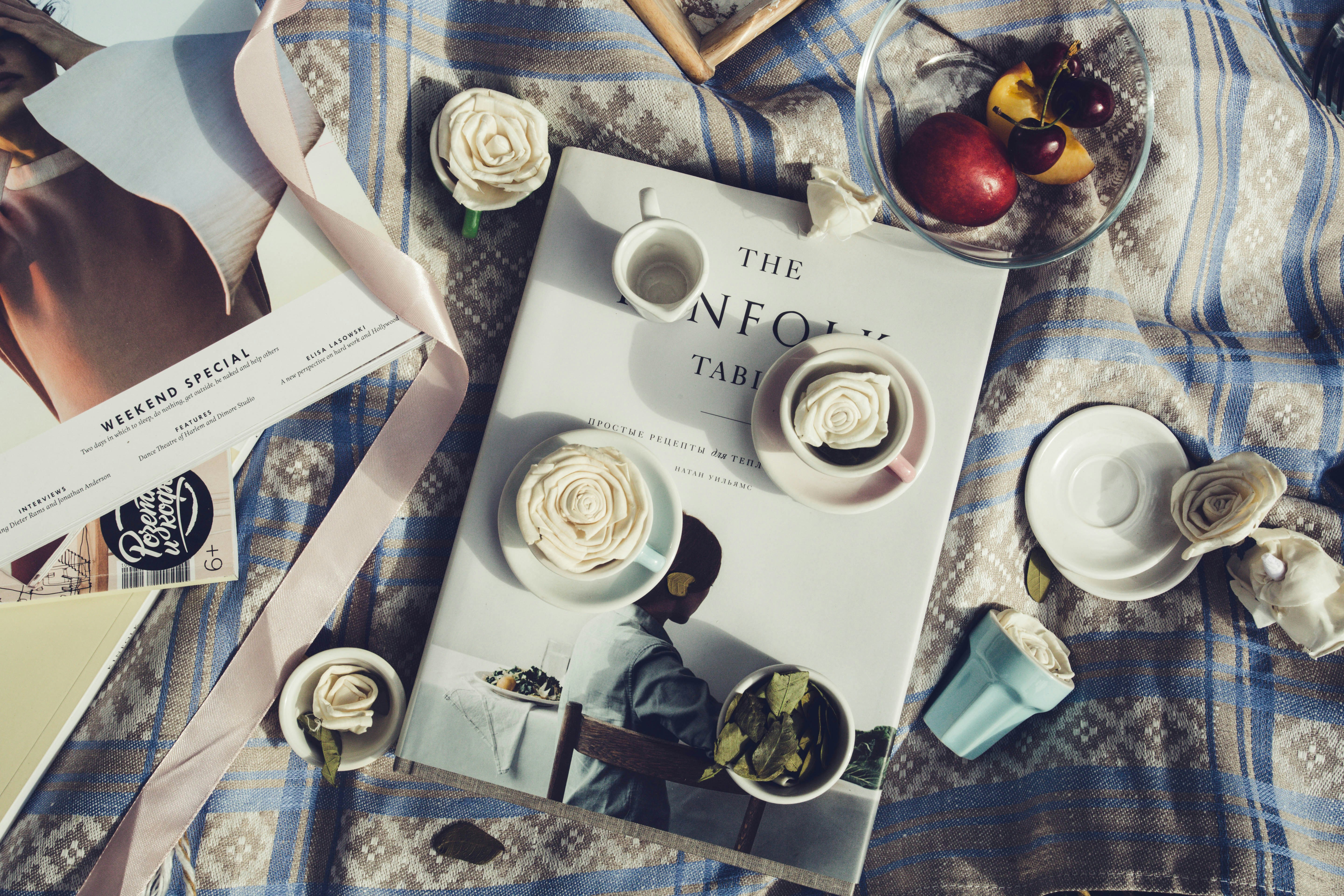 Picnic cups and a magazine on a checked blanket