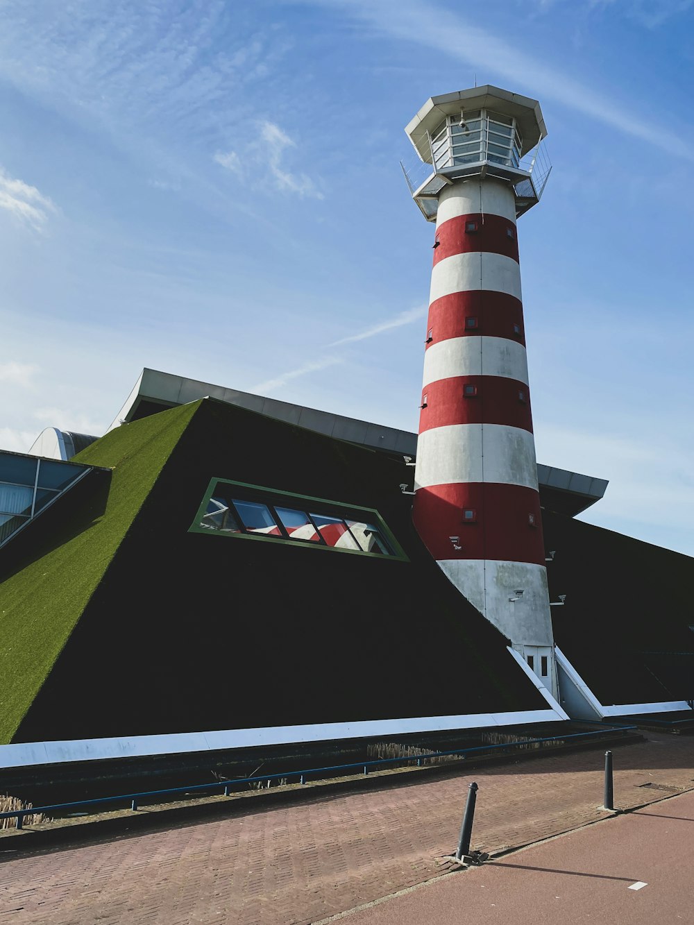 faro de rayas rojas y blancas bajo el cielo azul