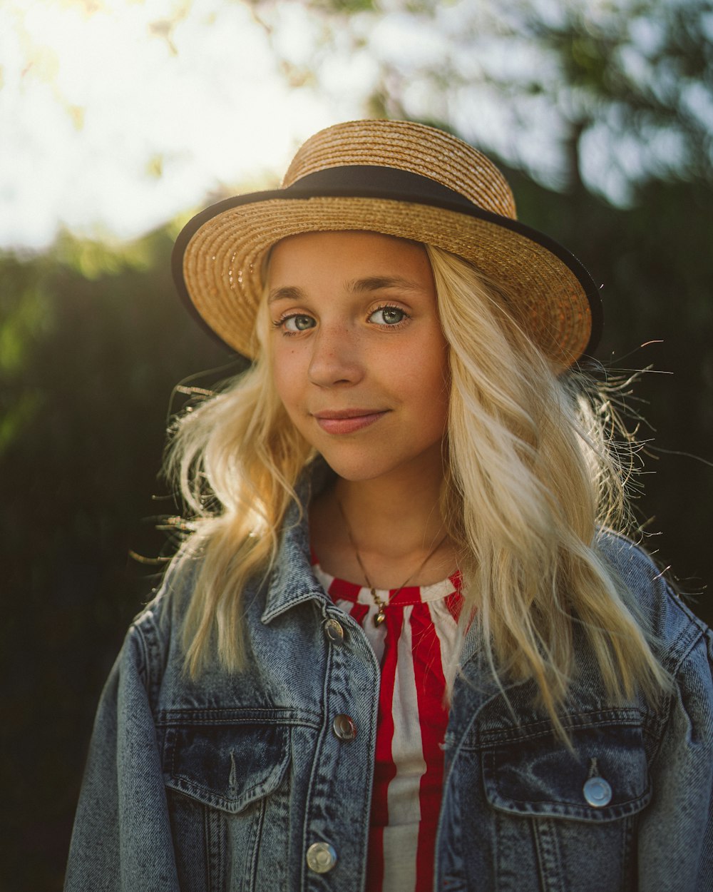 woman in blue denim jacket wearing brown fedora hat