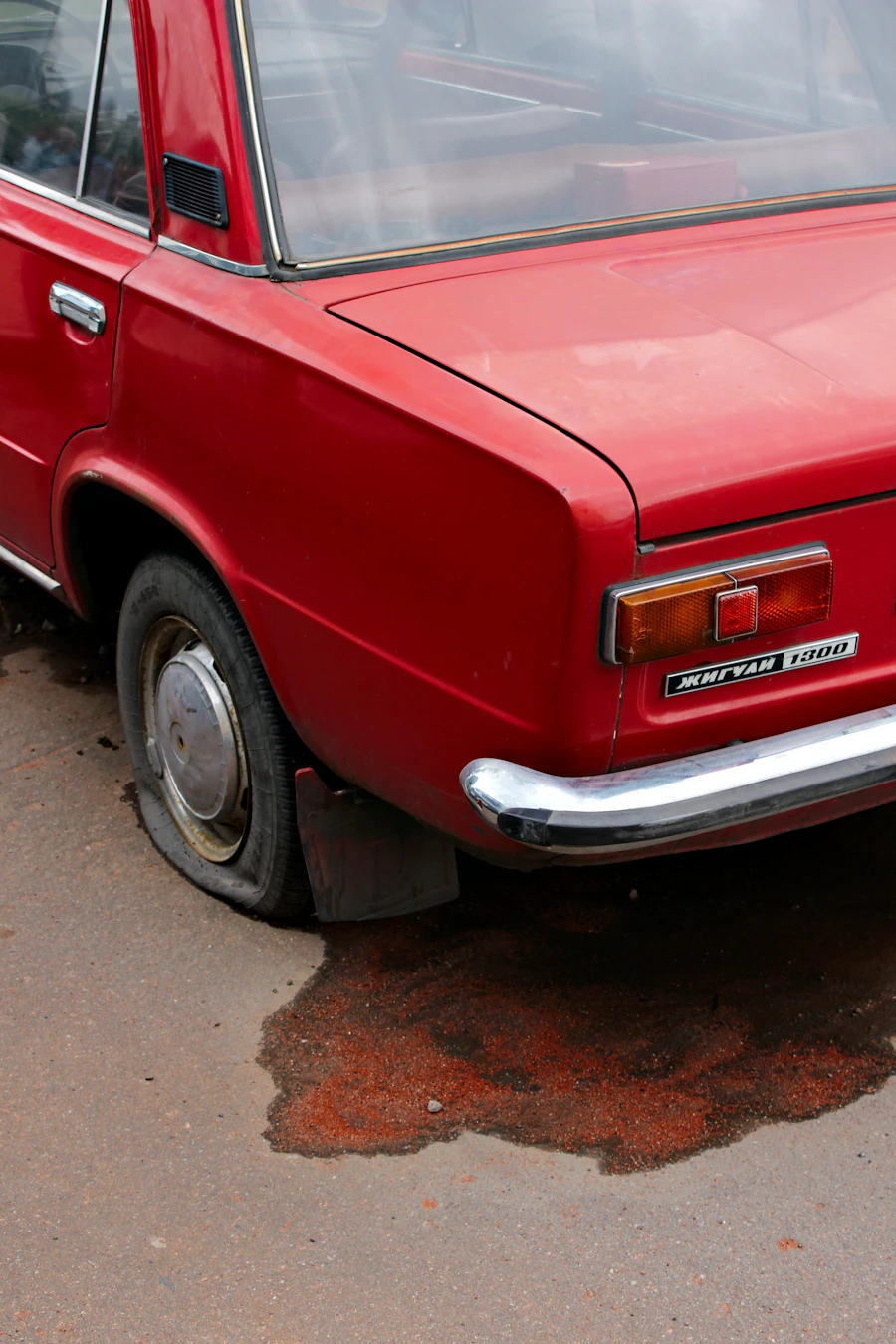 A car stopped at the roadside with a flat tyre