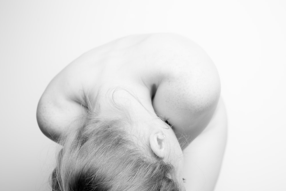 grayscale photo of woman lying on bed