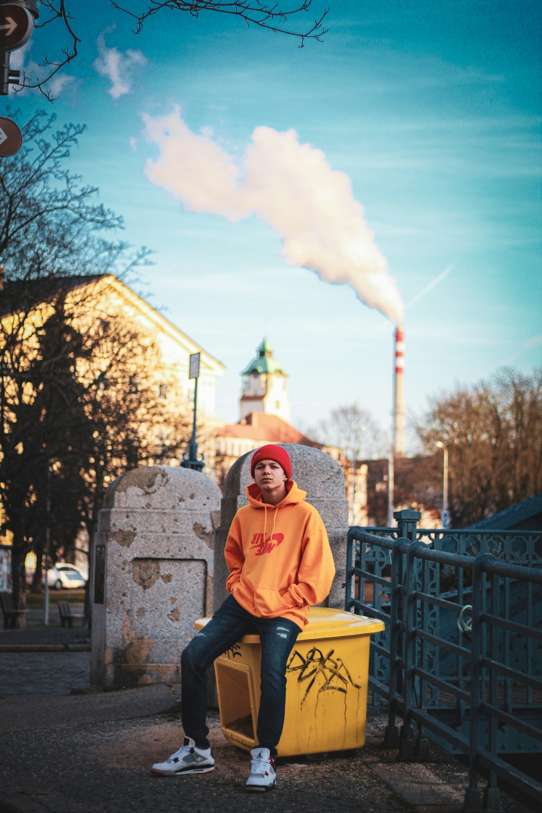 man in pink hoodie sitting on yellow plastic chair during daytime