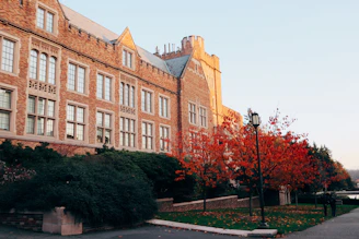 Historic brick building of George Washington Lodge #9 surrounded by mature trees on a sunny day.