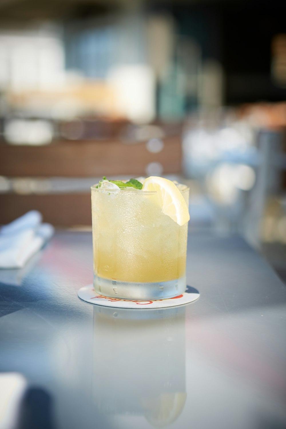 clear drinking glass with yellow liquid on white ceramic plate