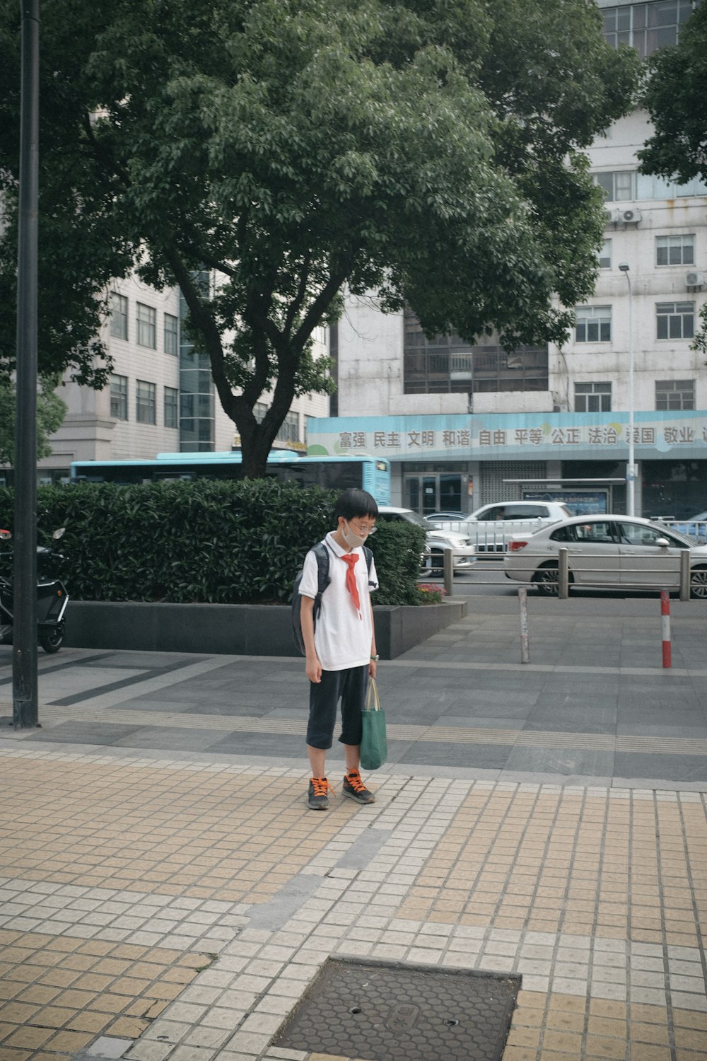 woman in white long sleeve shirt standing on sidewalk during daytime