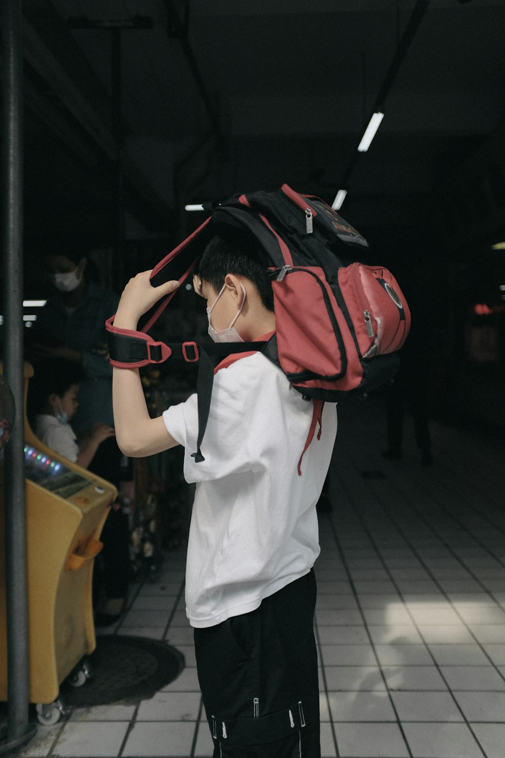 person in white shirt with red backpack