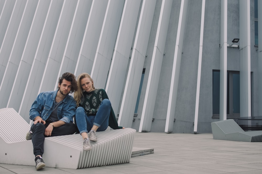 2 women sitting on white couch