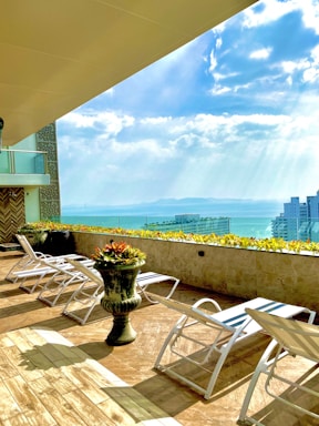 A rooftop terrace with lounge chairs and panoramic views of the skyline.