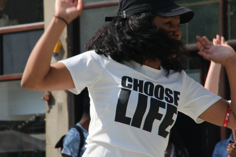 man in white and black crew neck t-shirt wearing black cap