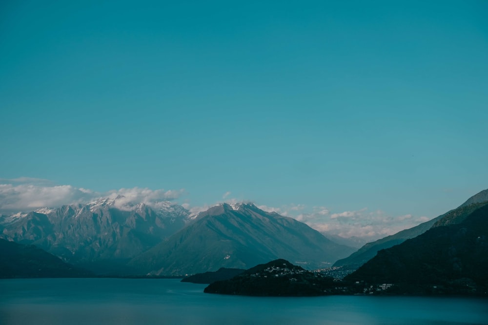 snow covered mountain near body of water during daytime