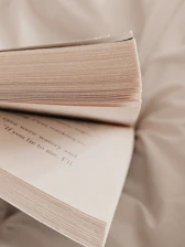 Close-up of an open book with soft lighting highlighting the pages in a cozy library corner.