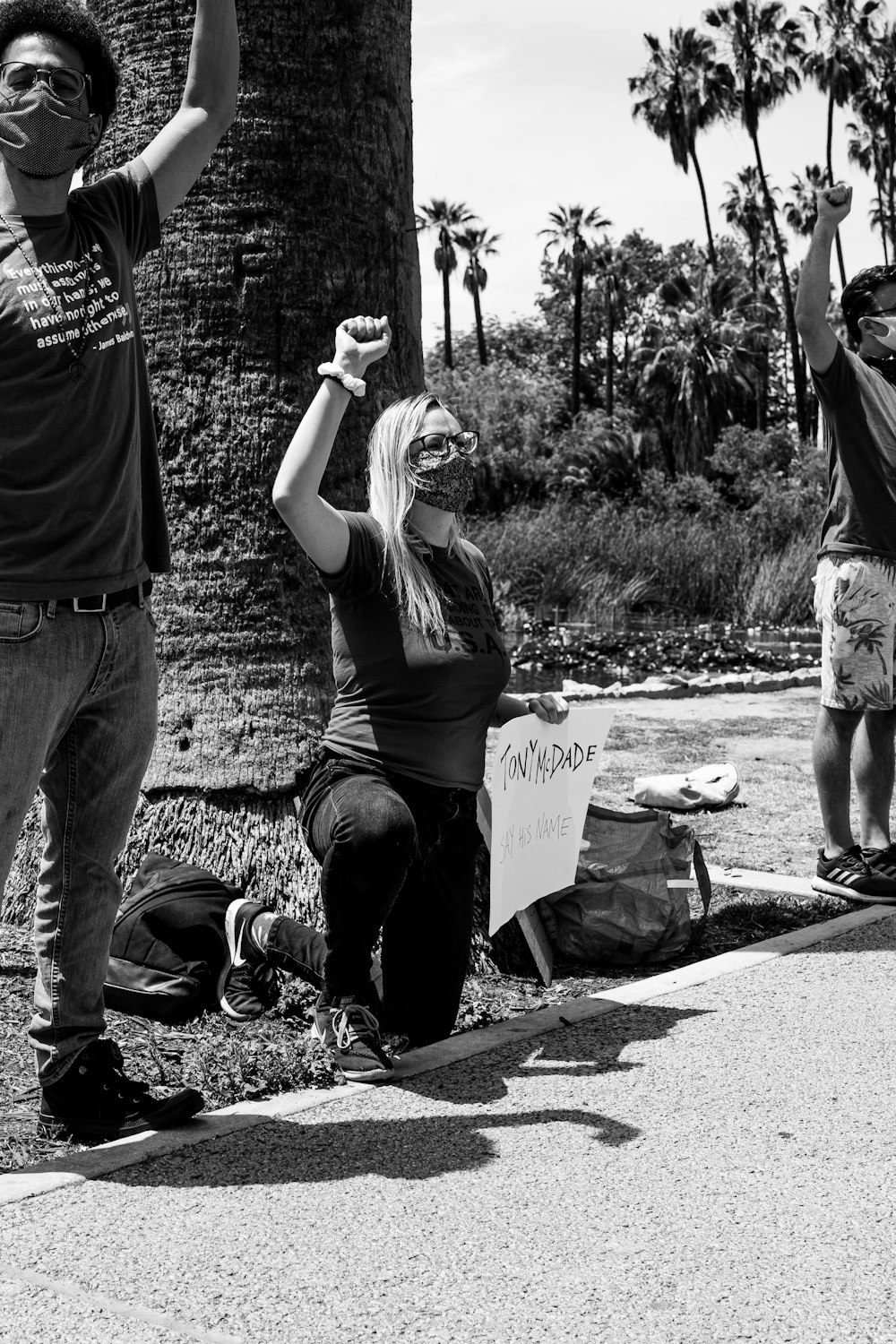 grayscale photo of woman in tank top and pants holding paper bag