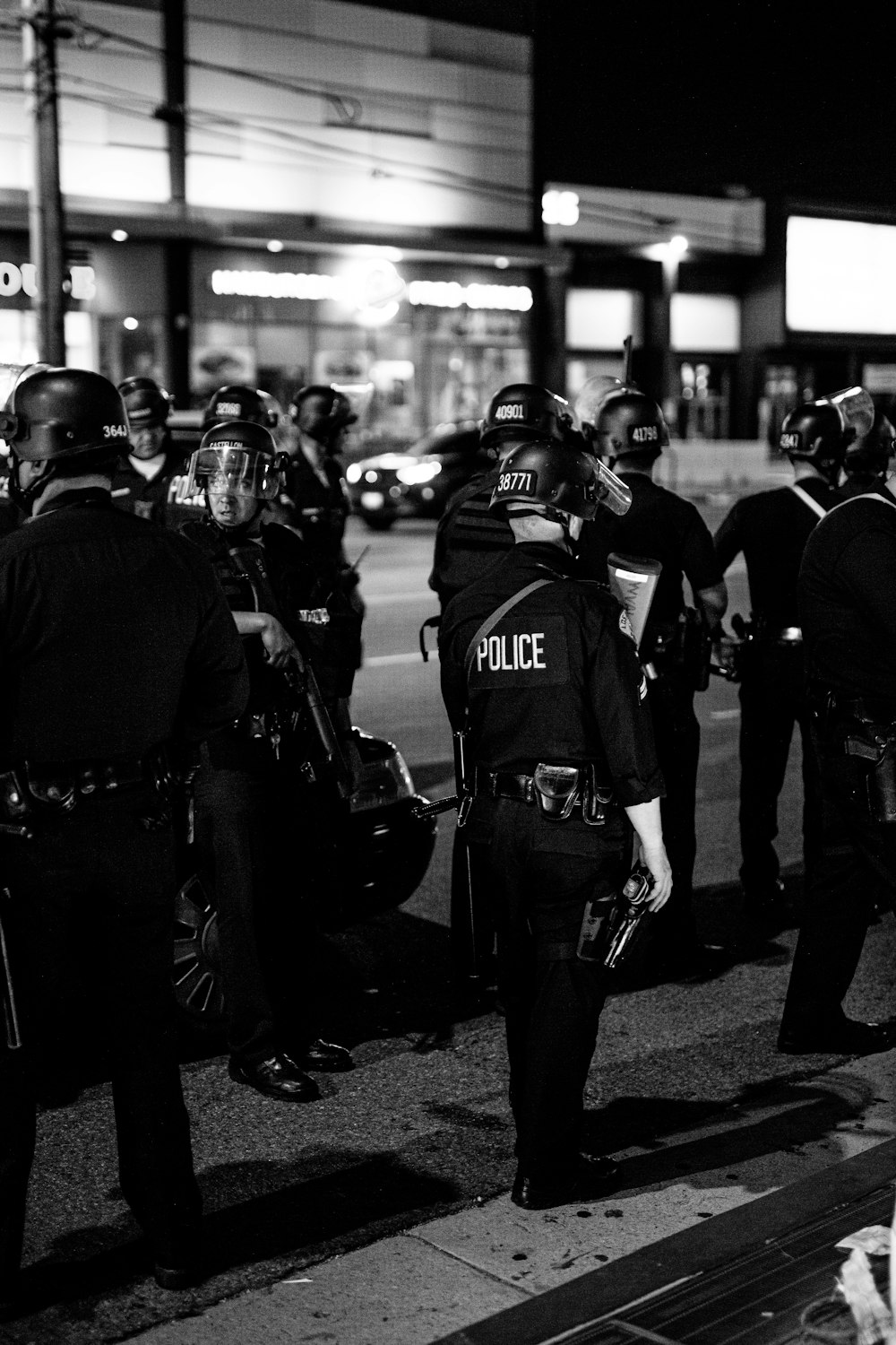 grayscale photo of 2 men in police uniform standing on road