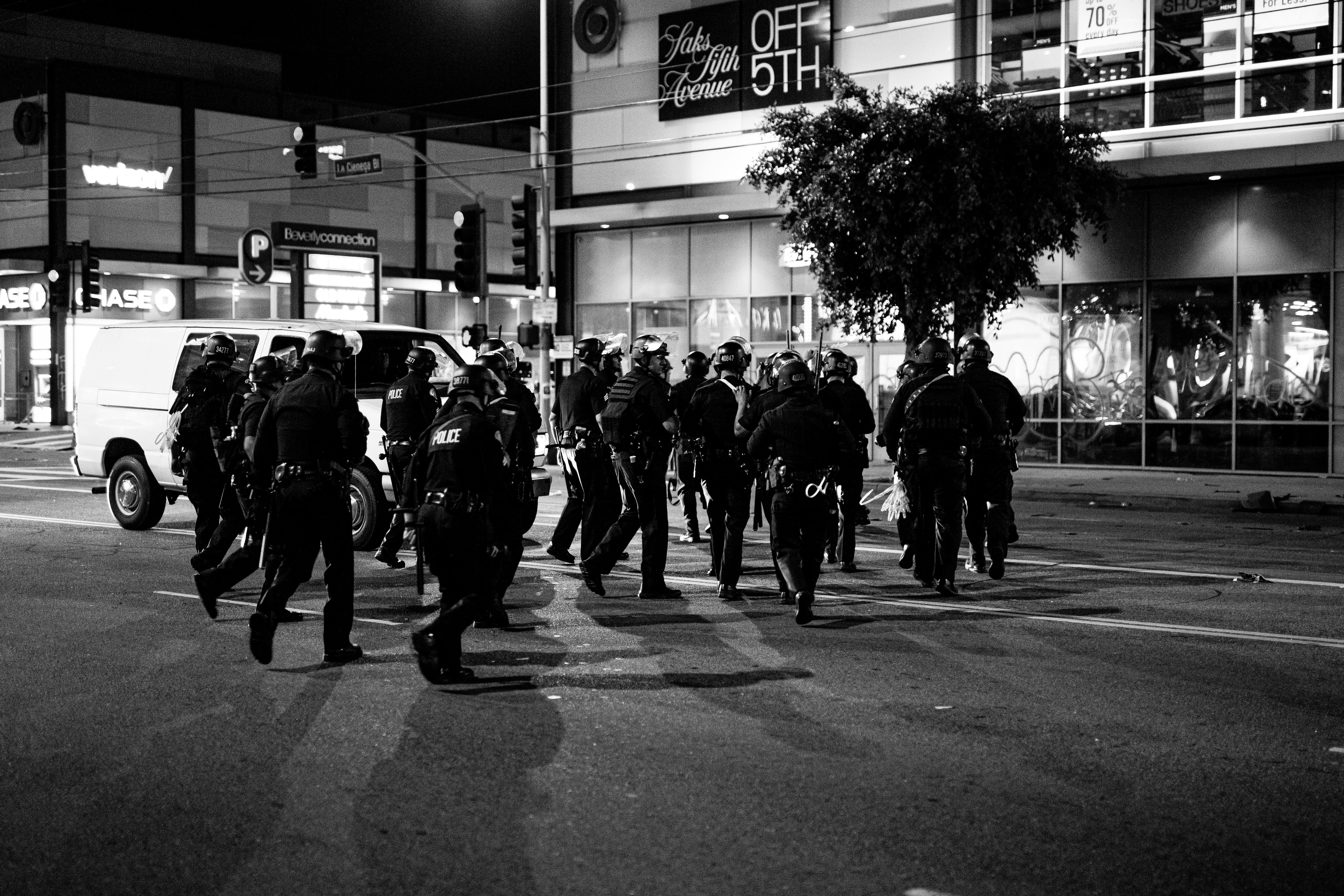 grayscale photo of people walking on sidewalk