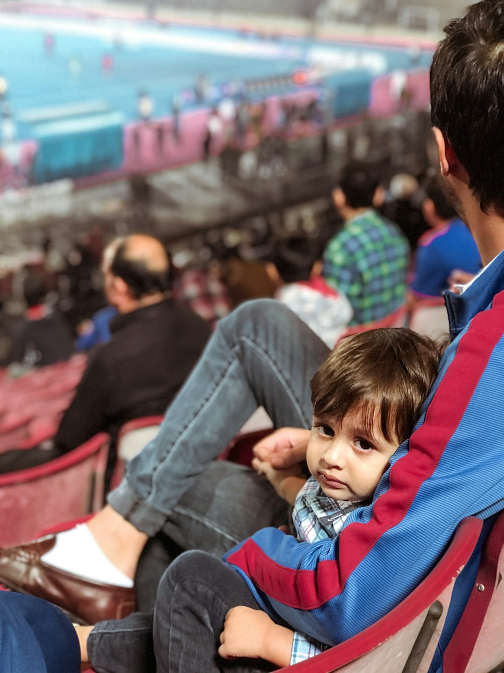 a man and a child sitting in a stadium