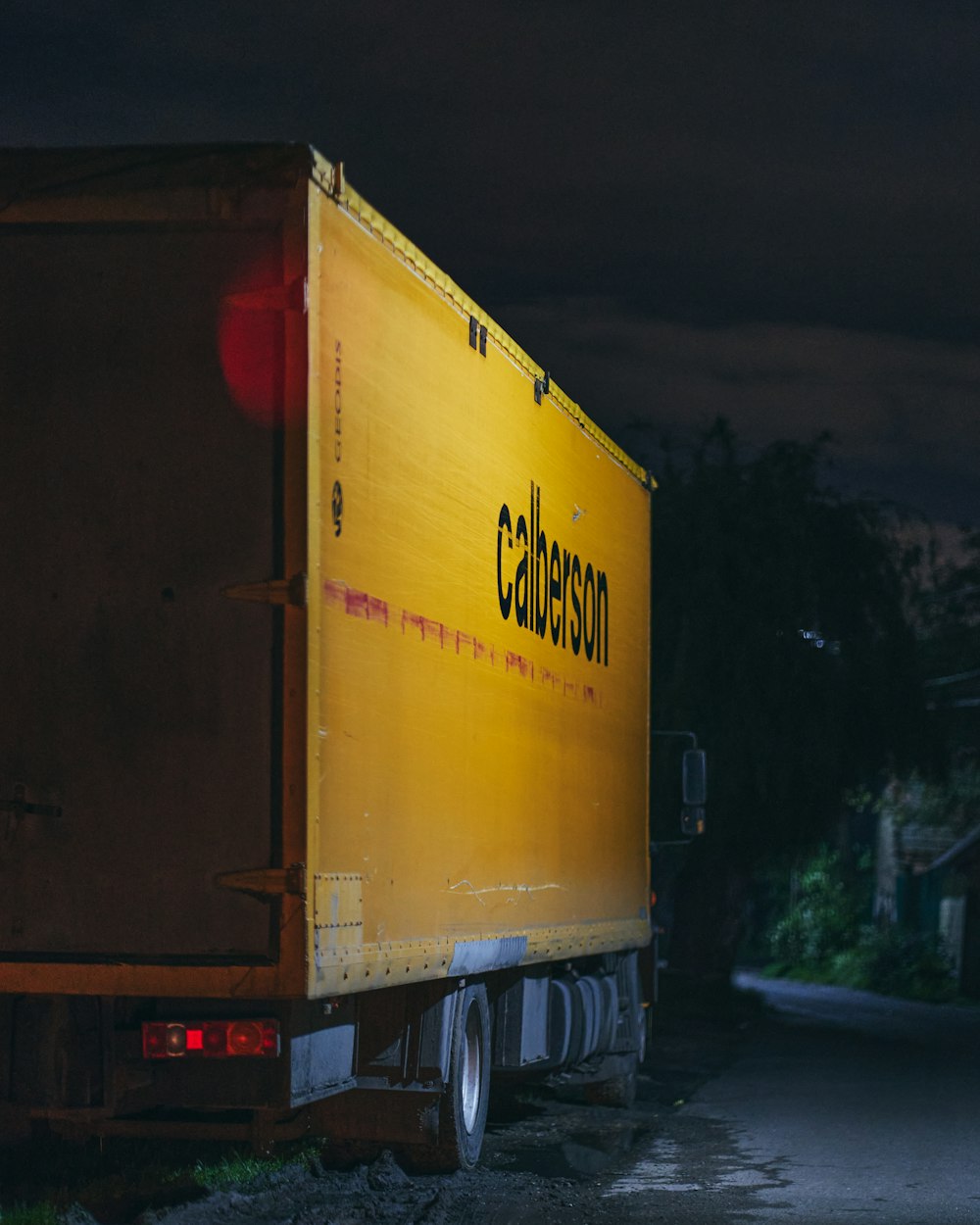 밤 시간 동안 도로에 노란색과 빨간색 상자 트럭