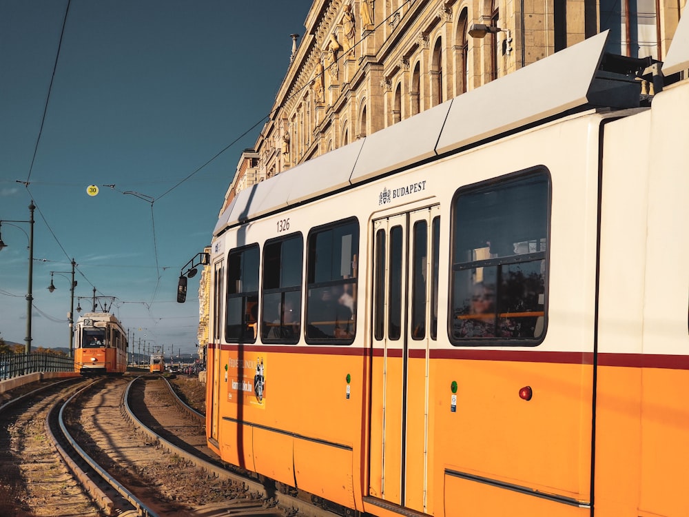 yellow and white train on rail tracks during daytime