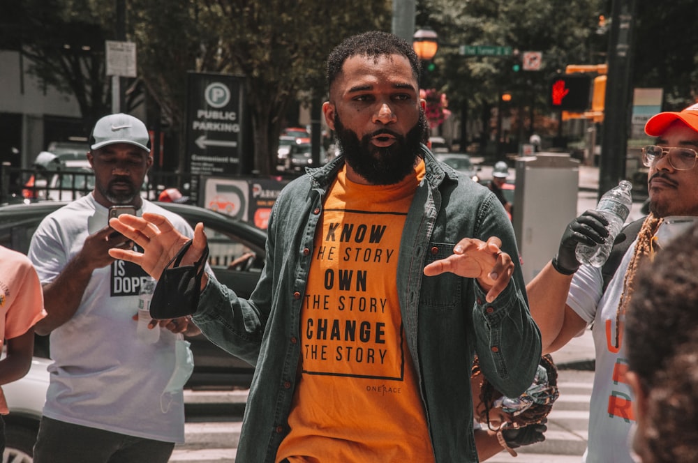 man in orange crew neck t-shirt with gray scarf