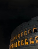 A dramatic nighttime shot of the Cunziria stone courtyard illuminated by red lights during a theatrical performance.