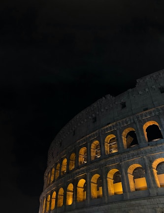 A dramatic nighttime shot of the Cunziria stone courtyard illuminated by red lights during a theatrical performance.