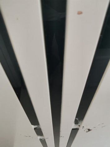 Vertical panels with a glossy finish. The surface has visible scratches and marks in several places.