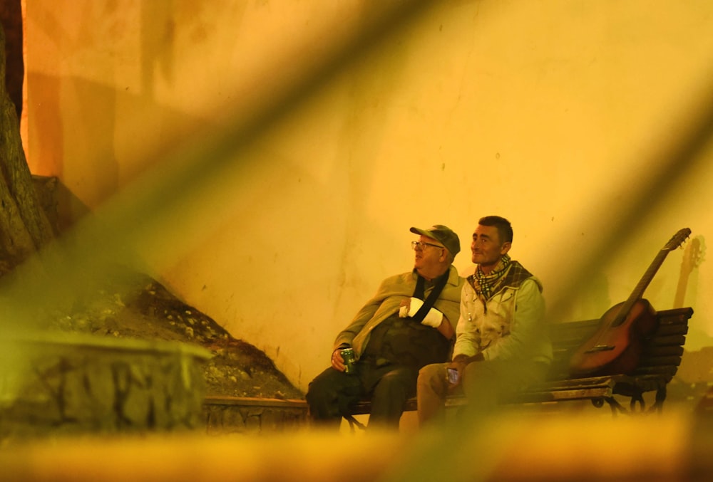 2 men sitting on green grass field