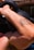 A muscular arm with a tattoo is lifting a black kettlebell, highlighting strength and physical activity.