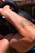 A muscular arm with a tattoo is lifting a black kettlebell, highlighting strength and physical activity.