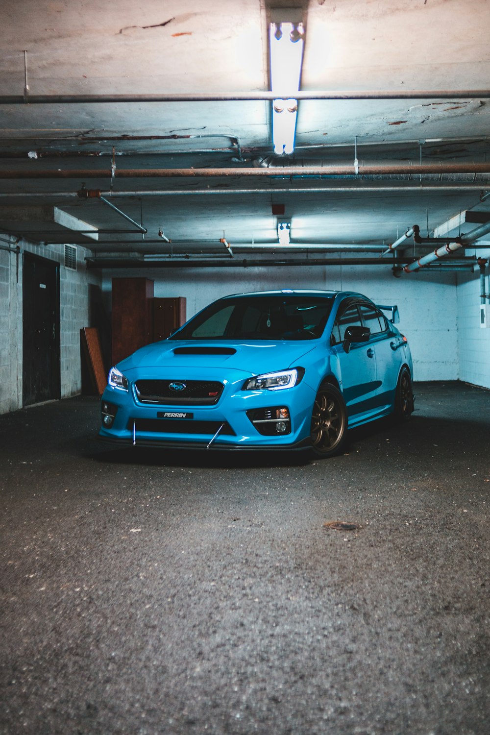 blue bmw m 3 parked on garage