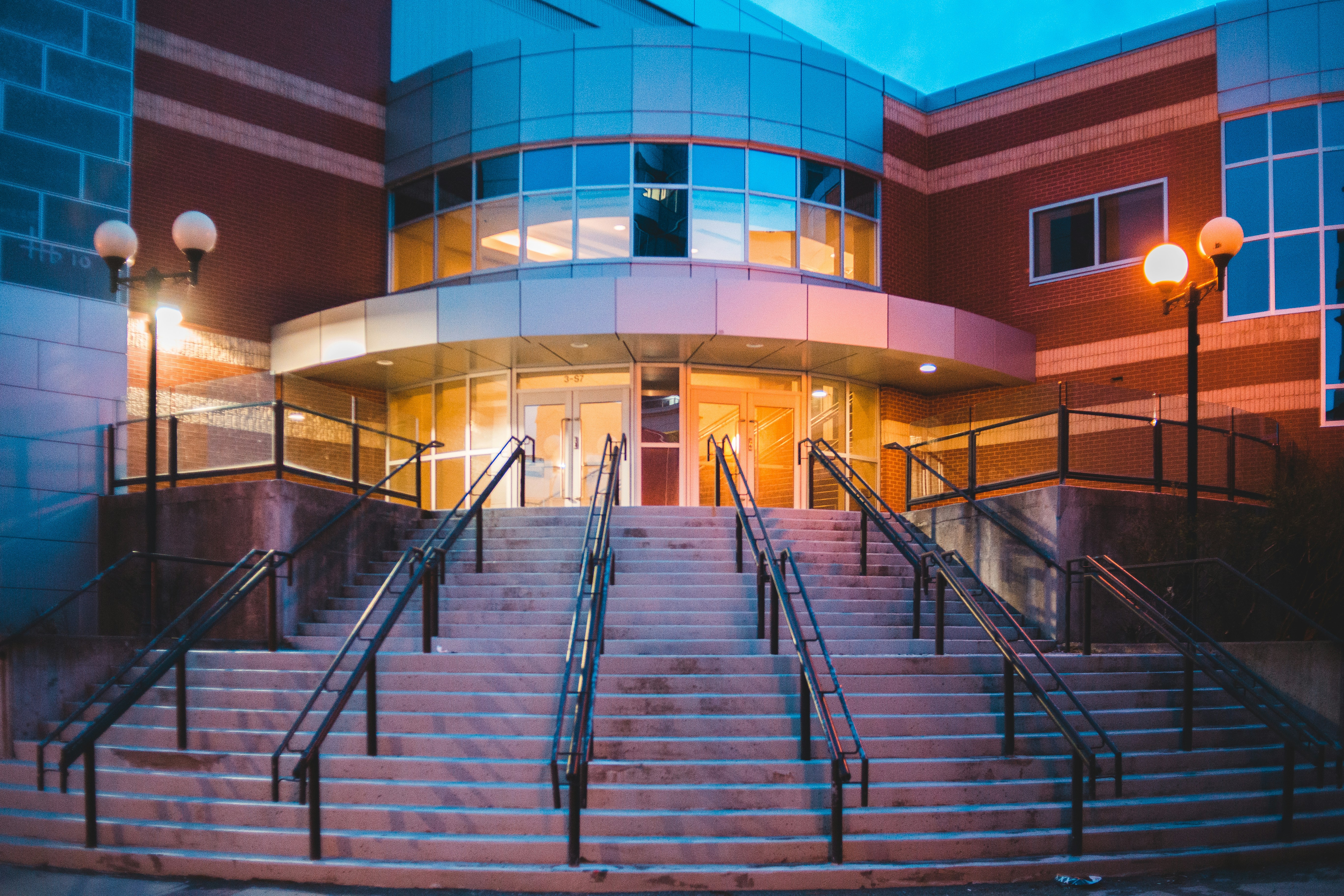black metal staircase near blue concrete building