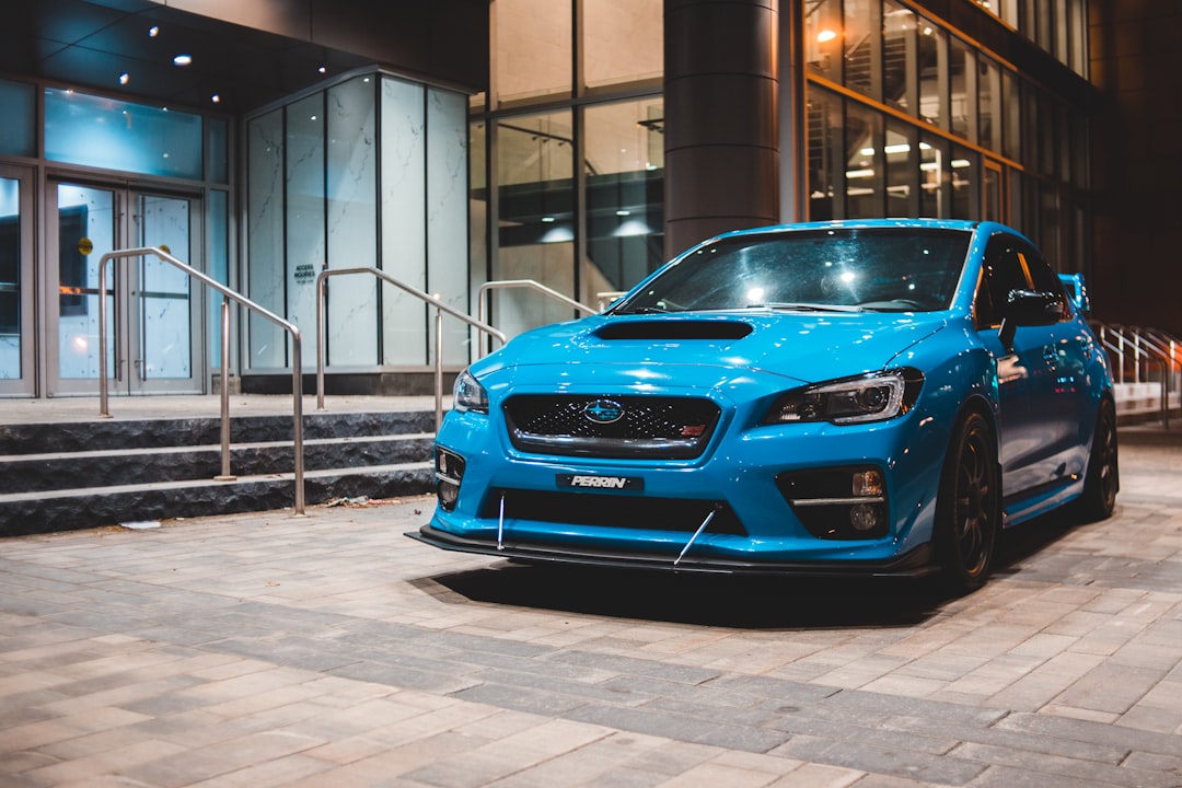 blue car parked near white building